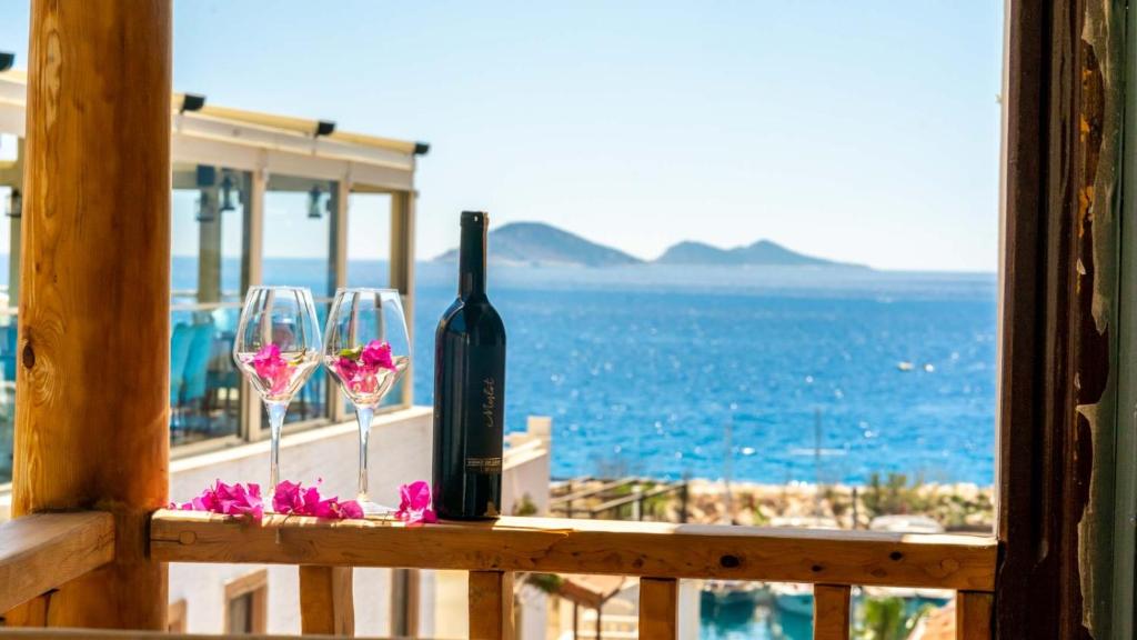 a bottle of wine and two wine glasses on a balcony at Old Trading House in Kalkan