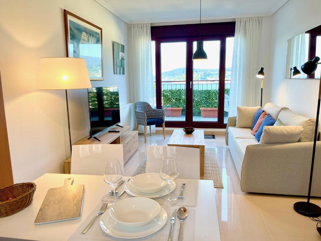 una sala de estar con una mesa con platos y copas de vino en The Cliffs - The Look Seiramar en Viveiro