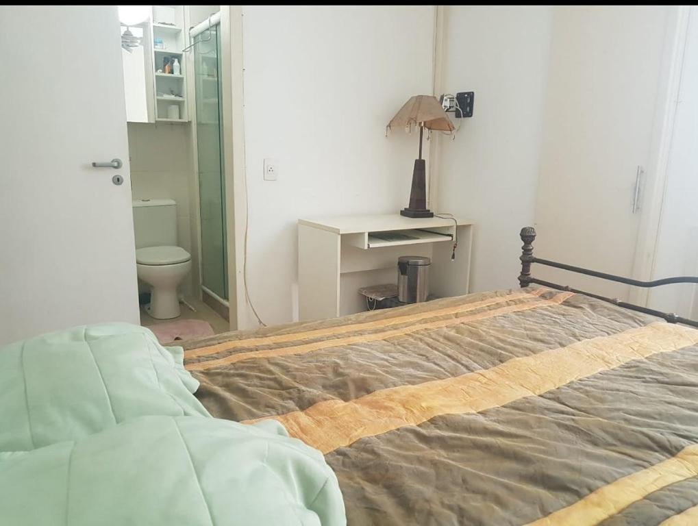 um quarto com uma cama e uma secretária com um candeeiro em Santa Clara Residence bedrooms no Rio de Janeiro
