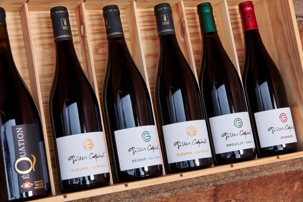 a row of wine bottles on a shelf at Les Glycines - Domaine Gilles Coperet in Régnié