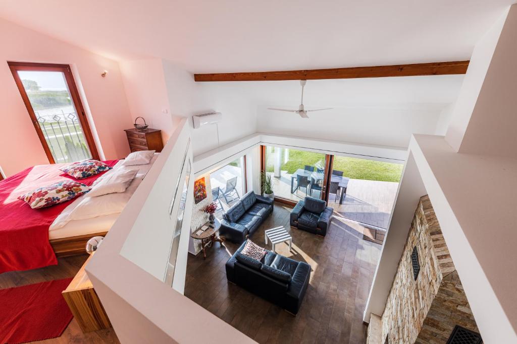 sypialnia na poddaszu z łóżkiem i 2 krzesłami w obiekcie Balaton View Apartment w mieście Balatonboglár