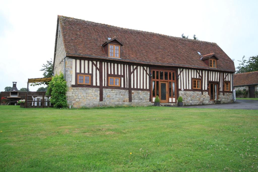 a large house with a green lawn in front of it at Holiday home Le Pressoir in Domfront