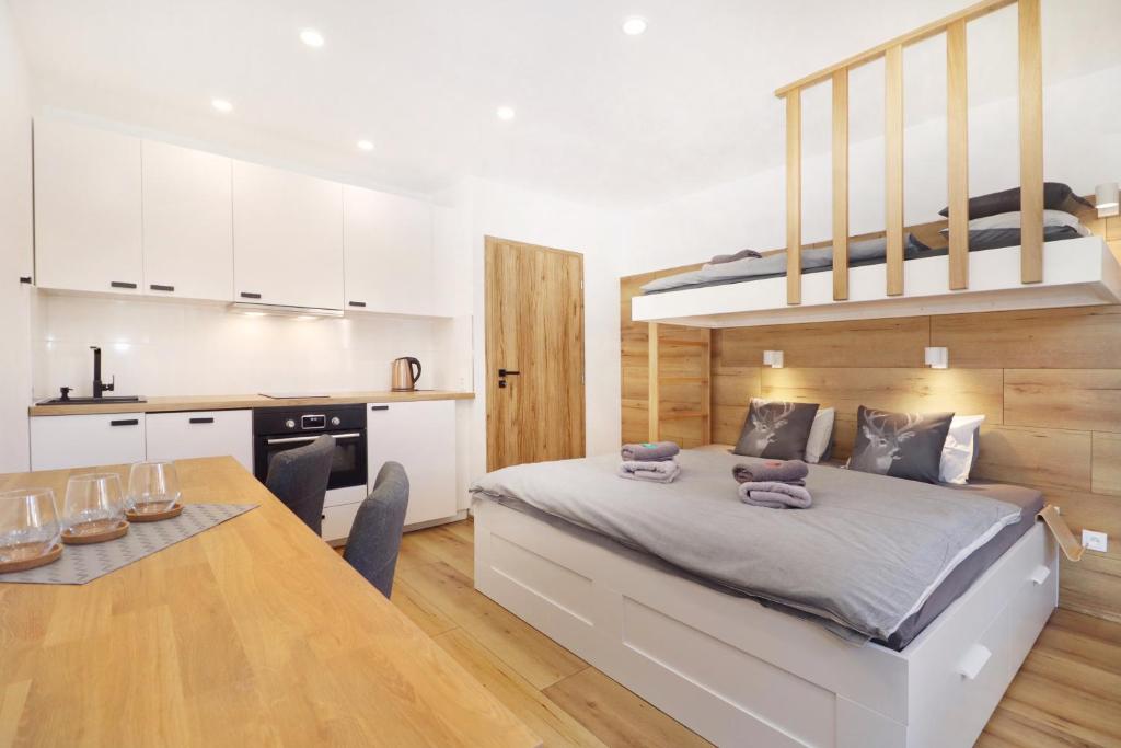 a bedroom with a loft bed and a dining table at Appartements Eisenstein in Bayerisch Eisenstein
