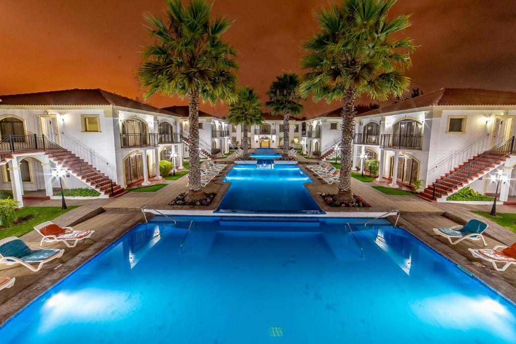 an image of a pool at a resort with palm trees at Aparthotel Serena Dream in La Serena