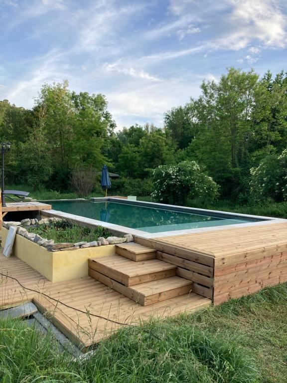 einen Pool mit einer Holzterrasse neben einem Pool in der Unterkunft Mas Paradiso in Allemagne-en-Provence