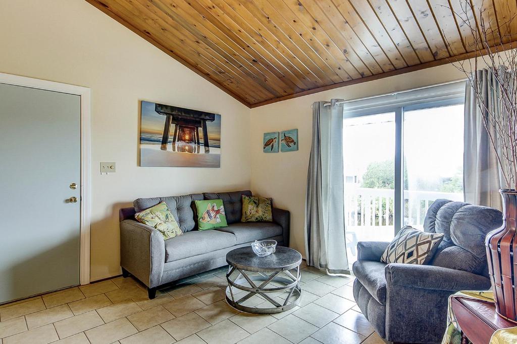 uma sala de estar com um sofá e uma mesa em Driftwood Villa - 237 em Edisto Beach