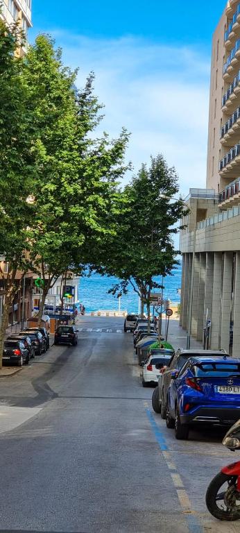 a parking lot with cars parked on the side of a street at Apartamento el Cid in Calpe