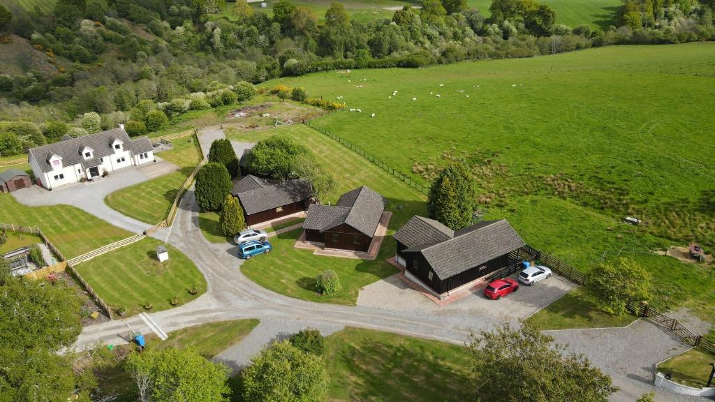 an aerial view of a house with a driveway and a yard at Glenview Chalet Park in Inverness