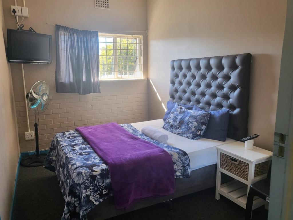 um quarto com uma cama grande e uma janela em MJ ACCOMODATION na Cidade do Cabo