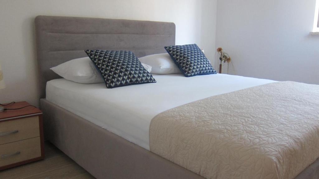 a bed with blue and white pillows on it at Apartment Marina in Srima
