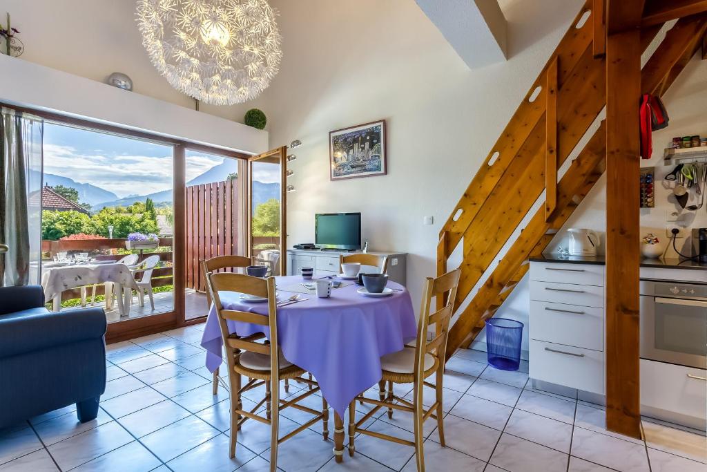 een keuken en eetkamer met een tafel en stoelen bij Apartplage in Saint-Jorioz