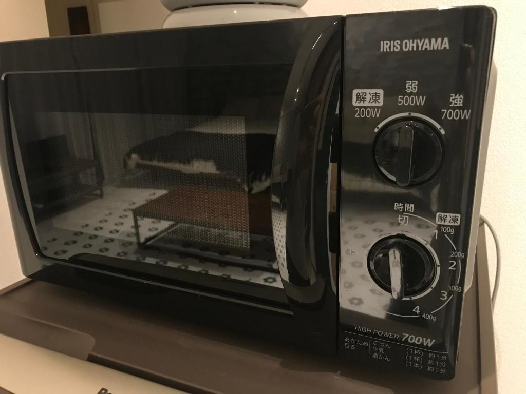 a black microwave oven sitting on top of a counter at Chatley Yoyogi 2 - Vacation STAY 12246 in Tokyo