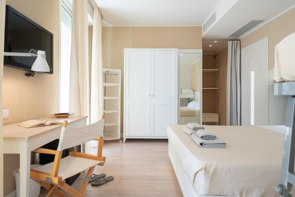a bedroom with a bed and a desk with a computer at Hotel Bristol in Cattolica