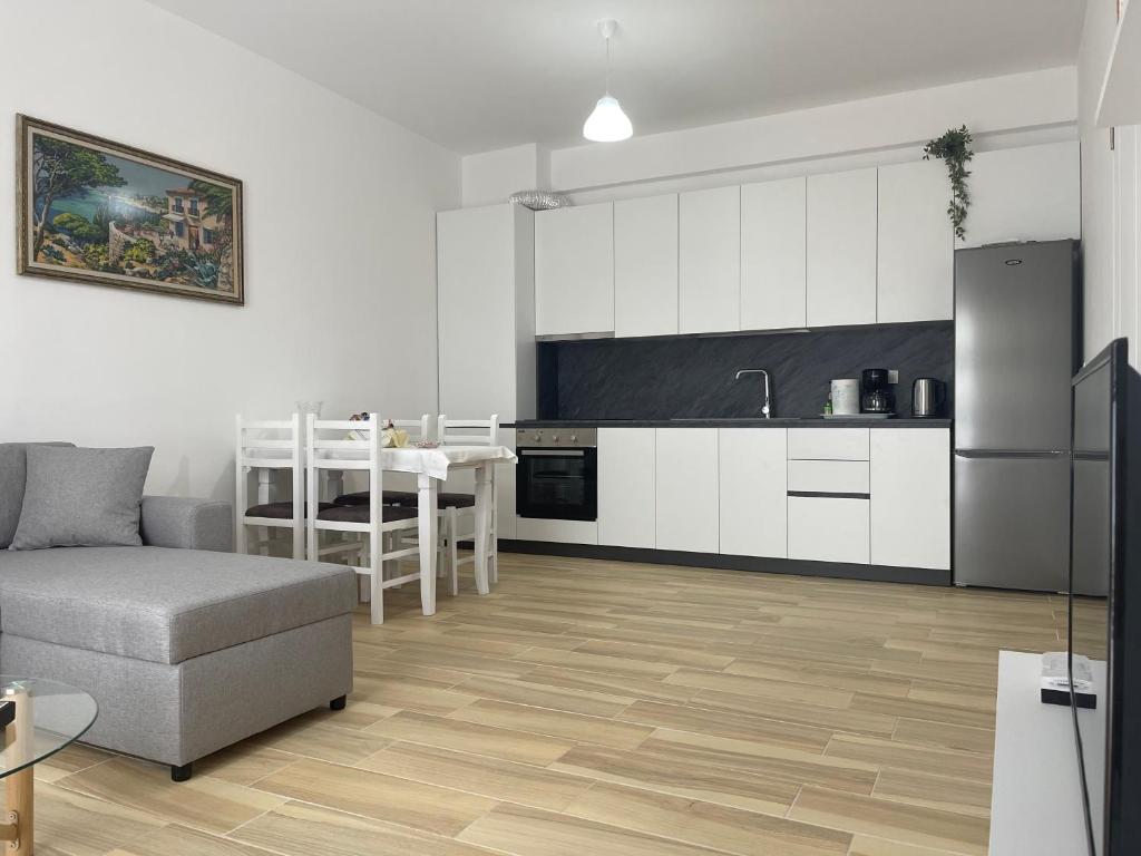 Atrium Residency في تيرانا: مطبخ وغرفة معيشة مع أريكة وطاولة