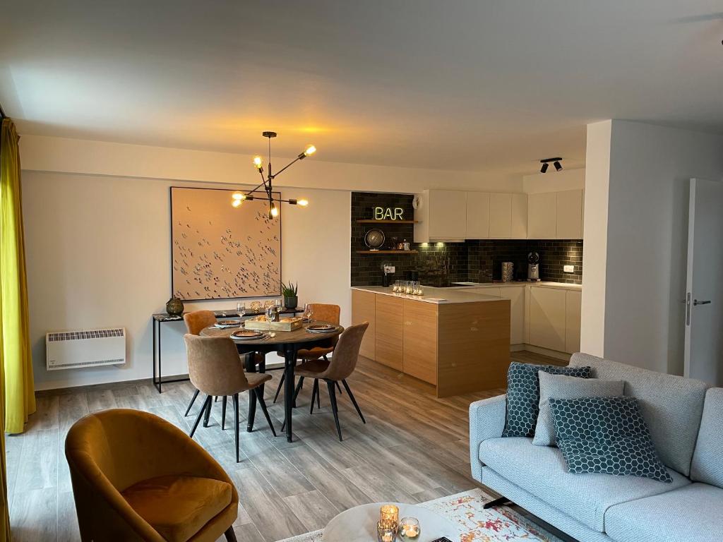 uma sala de estar e cozinha com uma mesa e um sofá em Fiets & Zee - Bike & Sea em Oostende