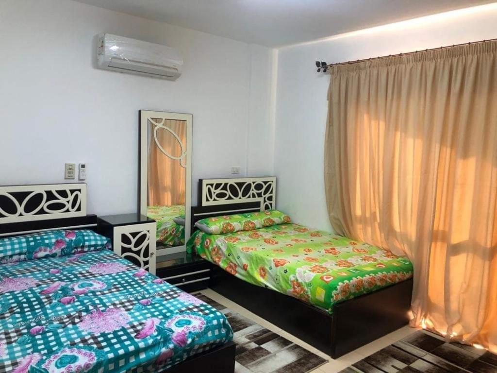 1 Schlafzimmer mit 2 Betten und einem Fenster in der Unterkunft بناية الصبيحي in Irbid