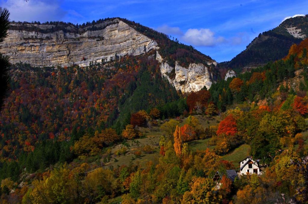 uma casa nas montanhas com folhagem de outono em Terre Rouge em Boulc