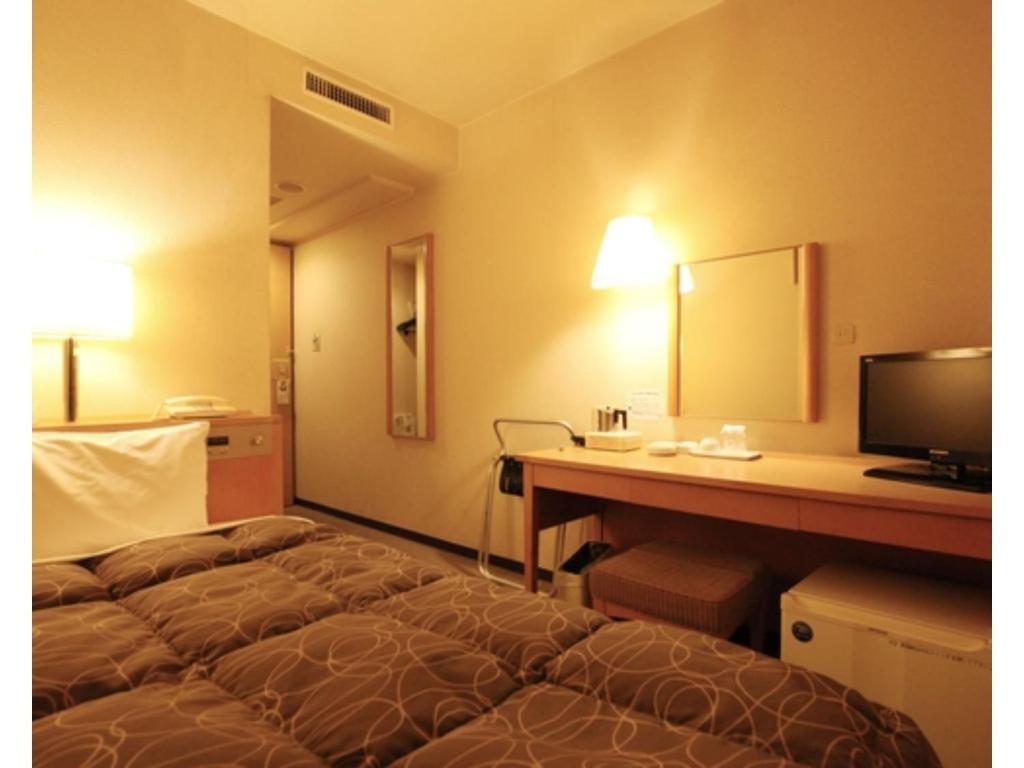 a hotel room with a bed and a desk with a mirror at AZ Inn Obu - Vacation STAY 71878v in Obu