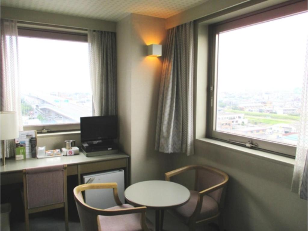 Cette chambre comprend un bureau, une table et 2 fenêtres. dans l'établissement Pulsesin in Kyoto - Vacation STAY 73544v, à Kyoto