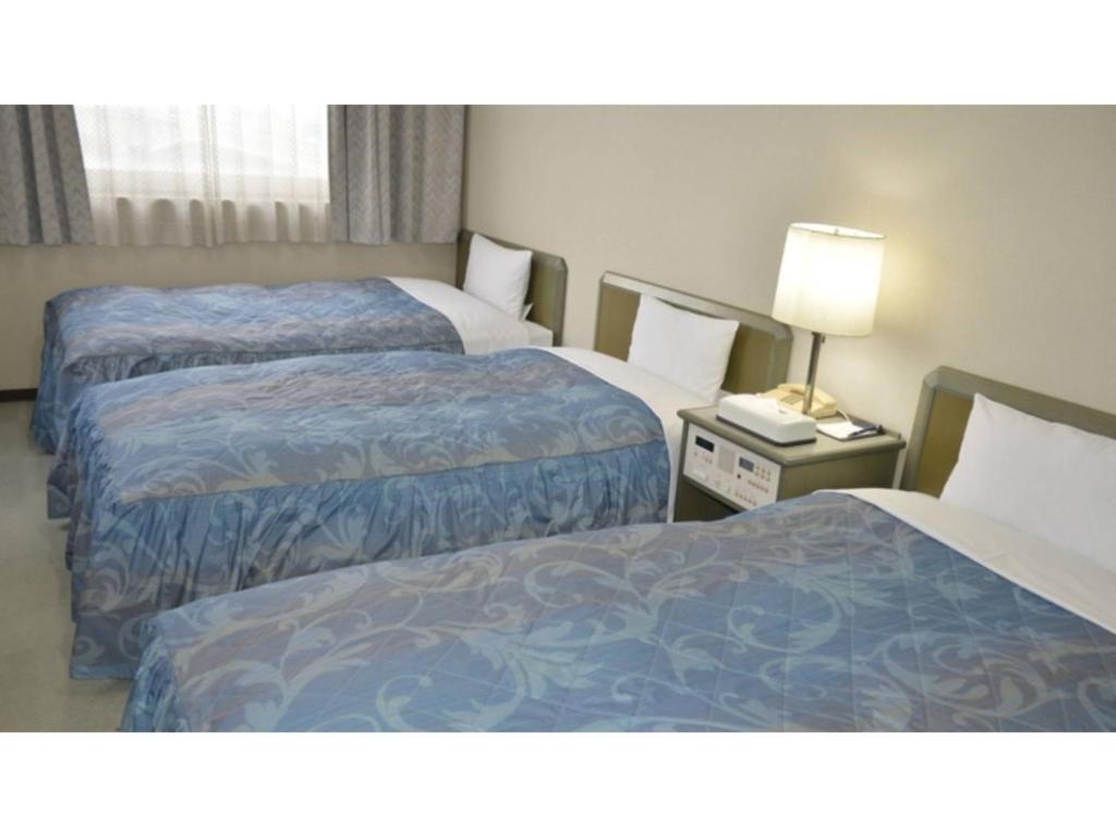 a hotel room with two beds and a lamp at Pulsesin in Kyoto - Vacation STAY 73559v in Kyoto