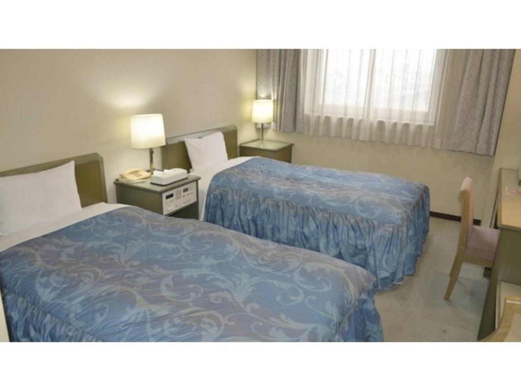 a hotel room with two beds and a chair at Pulsesin in Kyoto - Vacation STAY 73549v in Kyoto