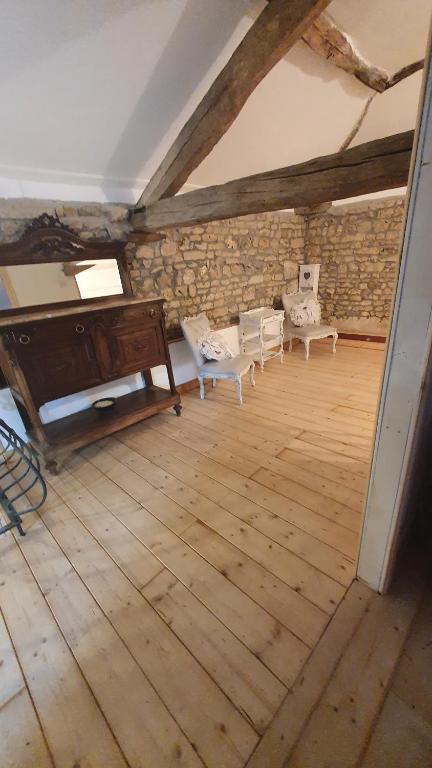 an attic room with a piano and chairs on a wooden floor at Chateau Mano in Mairé-lʼEveseault