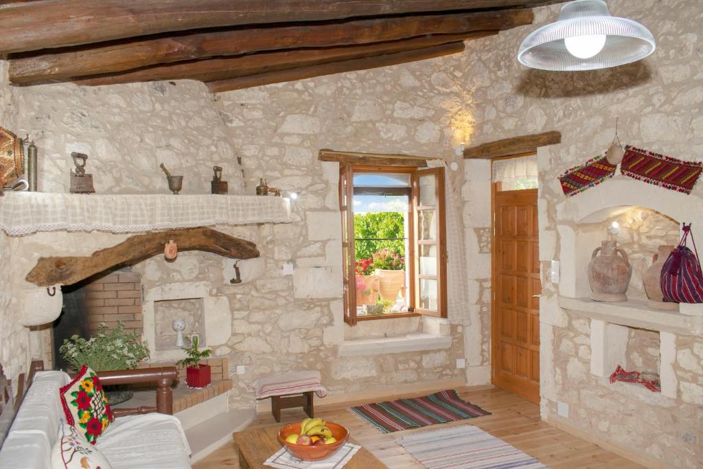 a living room with a stone wall and a fireplace at CASA CANTICO in Margarítai