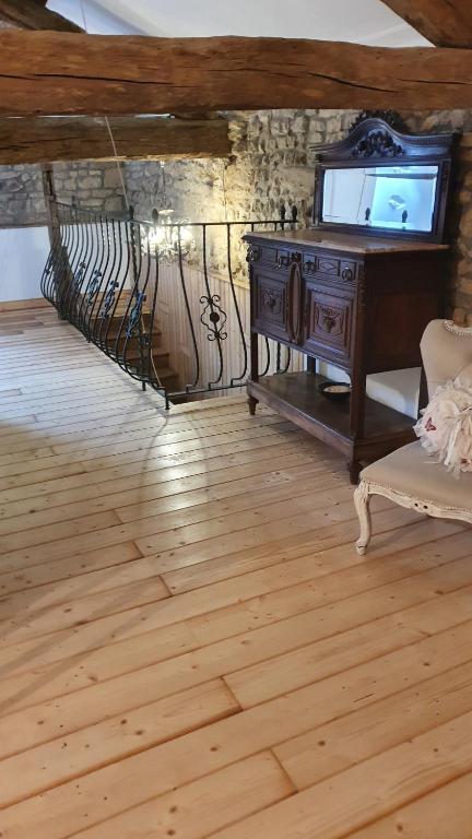 a living room with a tv and a wooden floor at Chateau Mano in Mairé-lʼEveseault