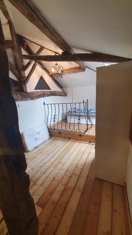 an attic room with a bed and wooden floors at Chateau Mano in Mairé-lʼEveseault