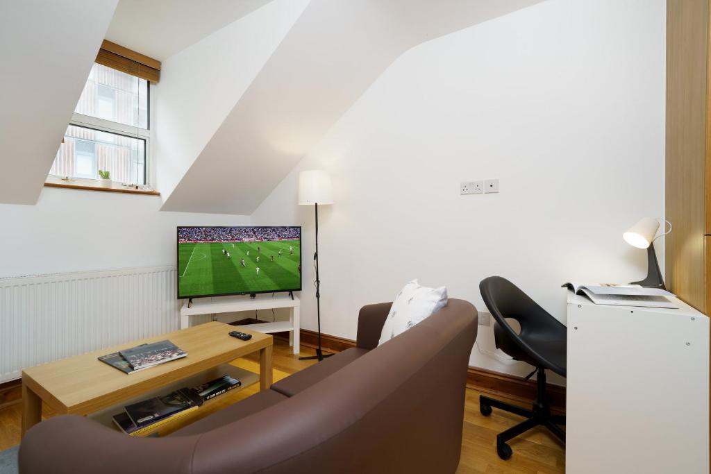 a living room with a couch and a tv at Flat in London in London