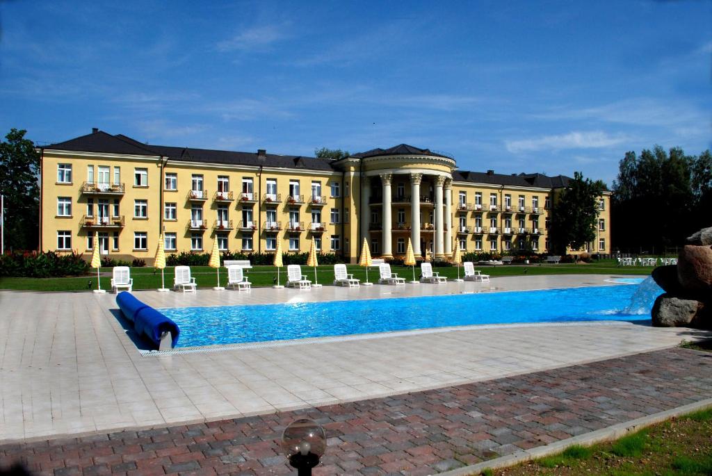 a large building with a pool in front of it at Rehabilitation Centre & SPA Draugystės sanatorija in Druskininkai