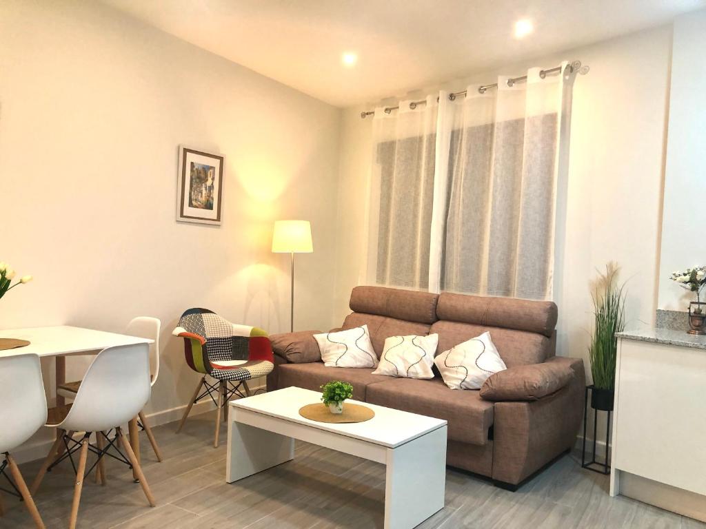 sala de estar con sofá y mesa en Apartamento Air Blanc Maracena Centro, en Maracena