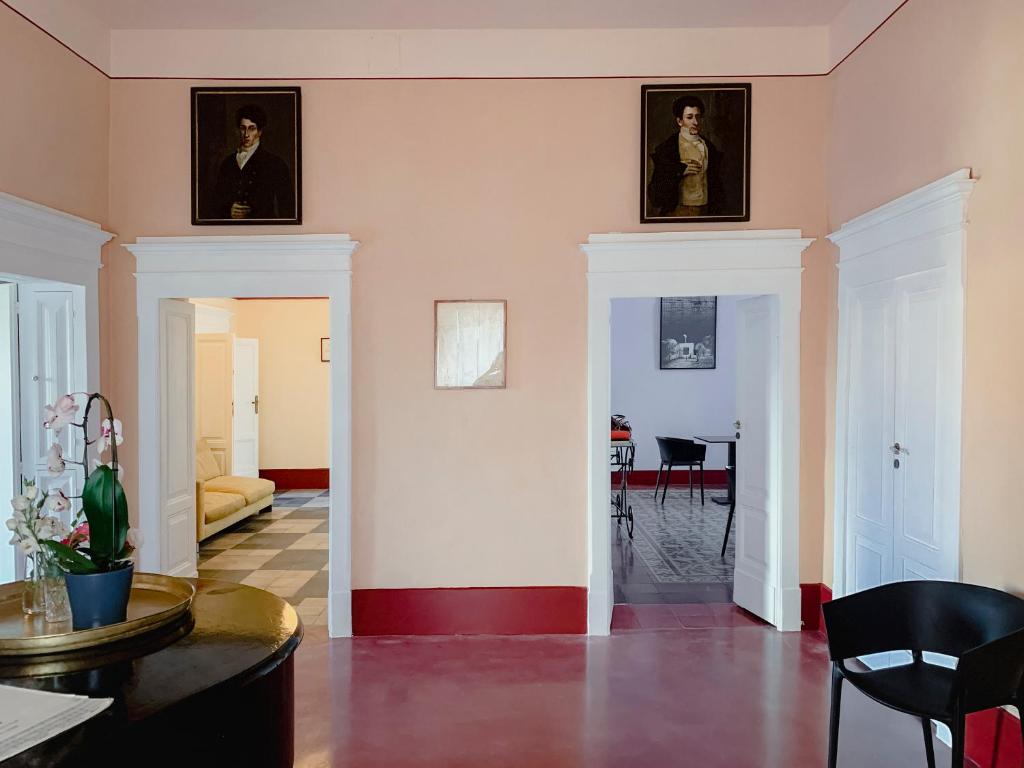 una sala de estar con retratos en las paredes y una mesa. en Villa Verlengia en Montesilvano