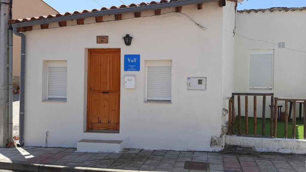 Casa blanca con puerta de madera y puerta en Casa Sillada, en Muelas del Pan