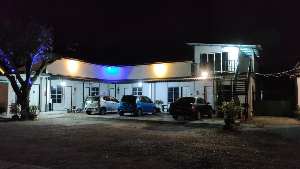 un edificio con coches estacionados en un estacionamiento por la noche en Aleesa Roomstay, en Pasir Puteh