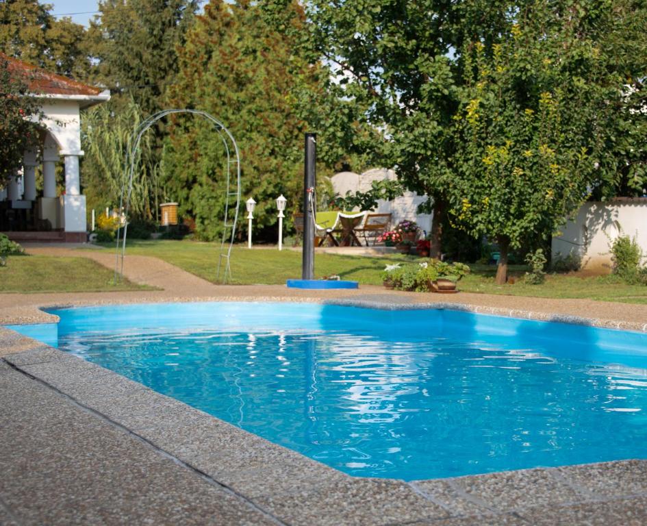 une piscine bleue dans une cour avec une fontaine dans l'établissement Penzión Emese, à Búč