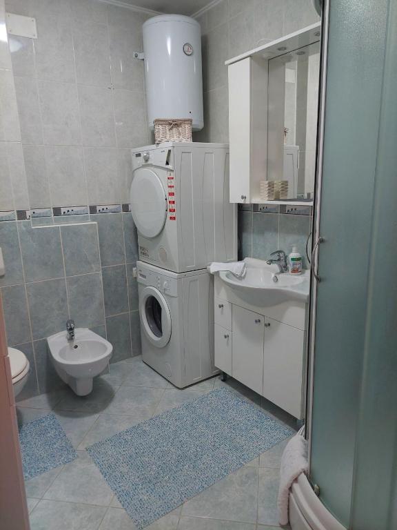 a bathroom with a washing machine and a sink at Apartman Sany in Bihać