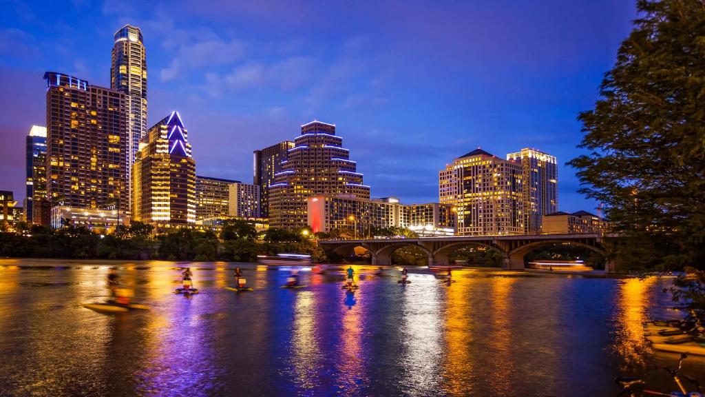 a city skyline with ducks in the water at night at Hotel Van Zandt in Austin