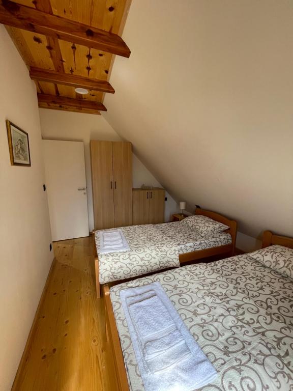 two beds in a small room with wooden floors at Mokrogorski konaci in Mokra Gora