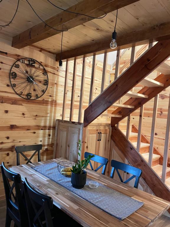 a dining room with a table and chairs and a clock at Mokrogorski konaci in Mokra Gora