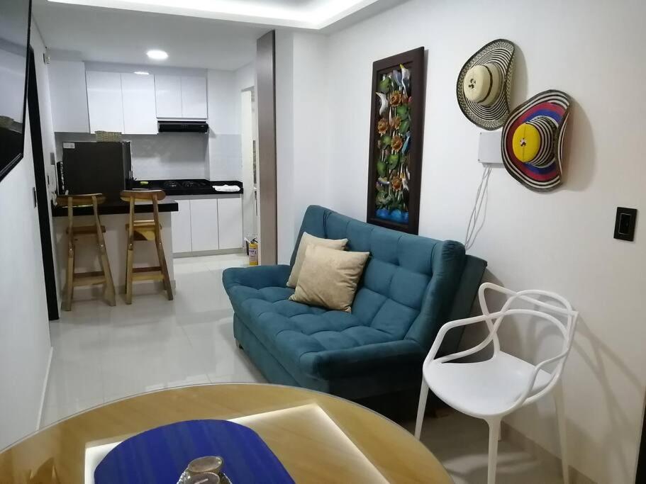 sala de estar con sofá azul y cocina en Super apartamento en la mejor ubicacion de Cartago en Cartago