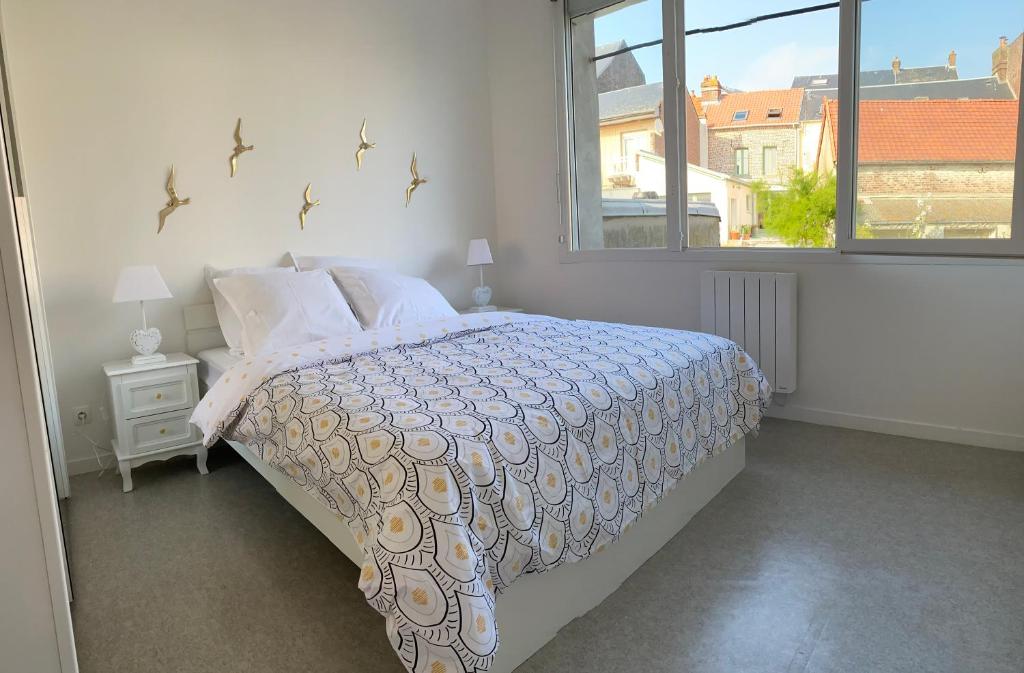 a bedroom with a bed and a window at Superbe appartement avec vue panoramique sur Mers in Mers-les-Bains