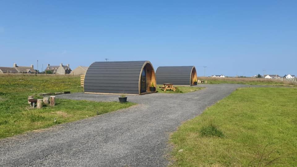 two small structures on a gravel road in a field at North Point Pods NC500 in Thurso