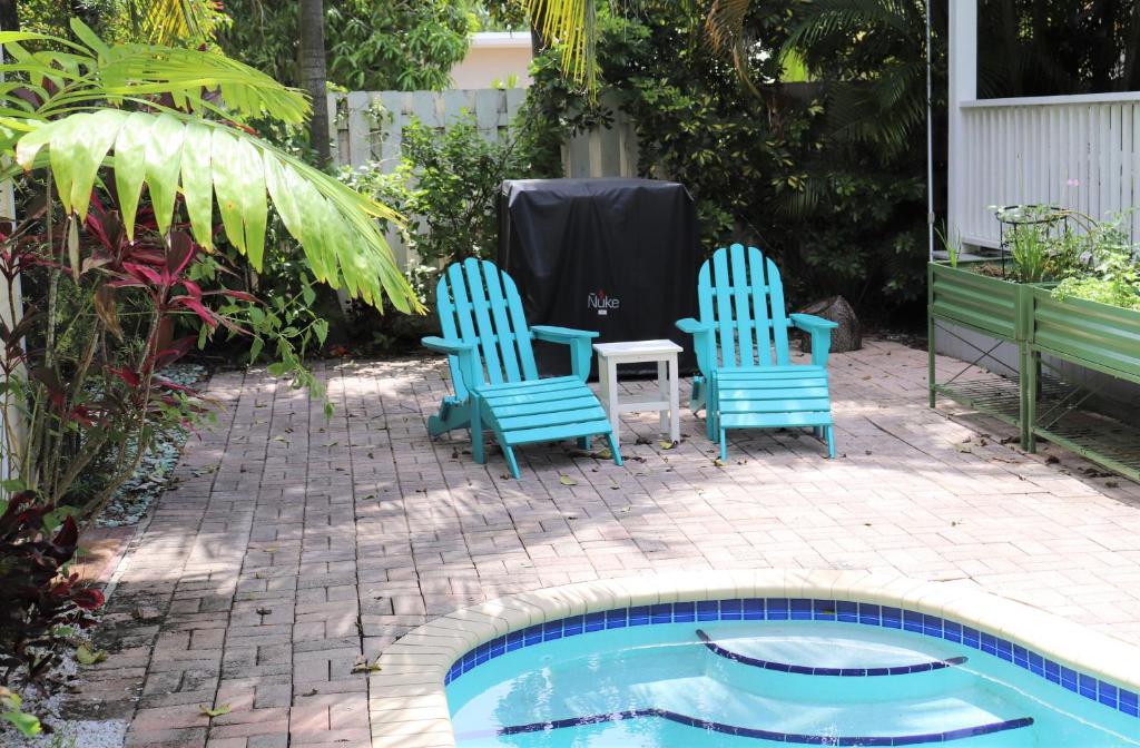 2 sillas y una mesa junto a la piscina en Upper East Side Oasis, en Miami