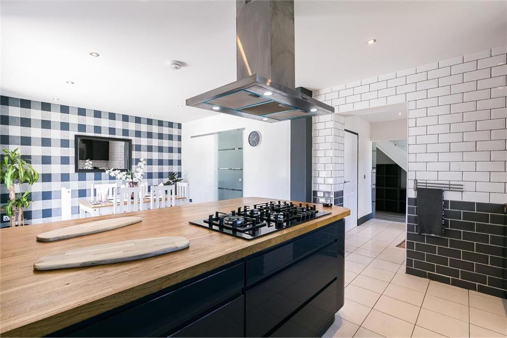 uma cozinha com um balcão com uma placa de fogão em Dreghorn House - 10 Beds 2,5 Ba - Private Parking - Free Wifi em Edimburgo