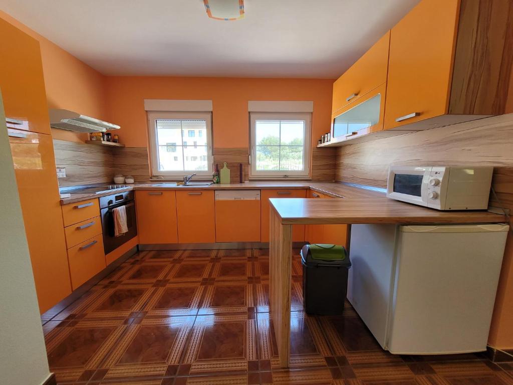 a kitchen with orange cabinets and a wooden counter top at Villa Georgina in Vodice
