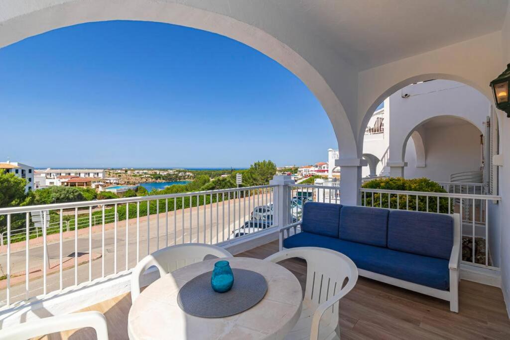 a balcony with a blue couch and a table at Apartamento Castellsol 211 in Arenal d'en Castell