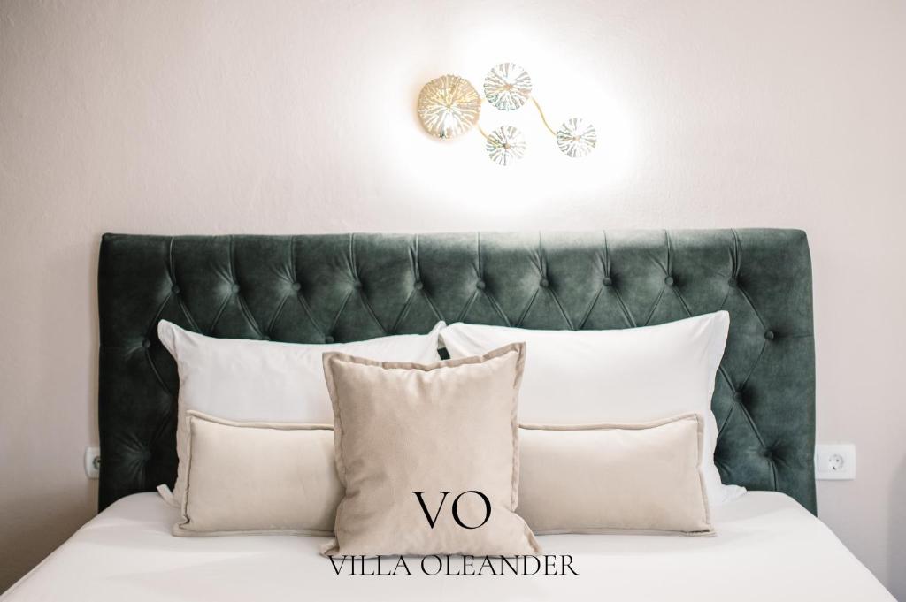 Villa Oleander في أولتسينج: سرير مع وسائد بيضاء و اللوح الأمامي أخضر