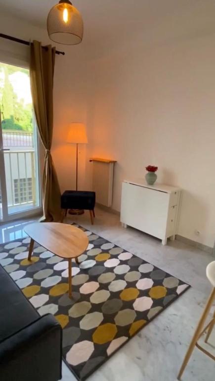 salon z kanapą, stołem i dywanem w obiekcie Appartement entier. Nice Riquier w Nicei