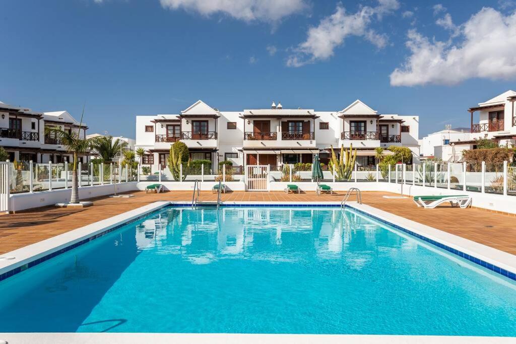 una grande piscina di fronte ad alcune case di Sweet Celia a Playa Blanca